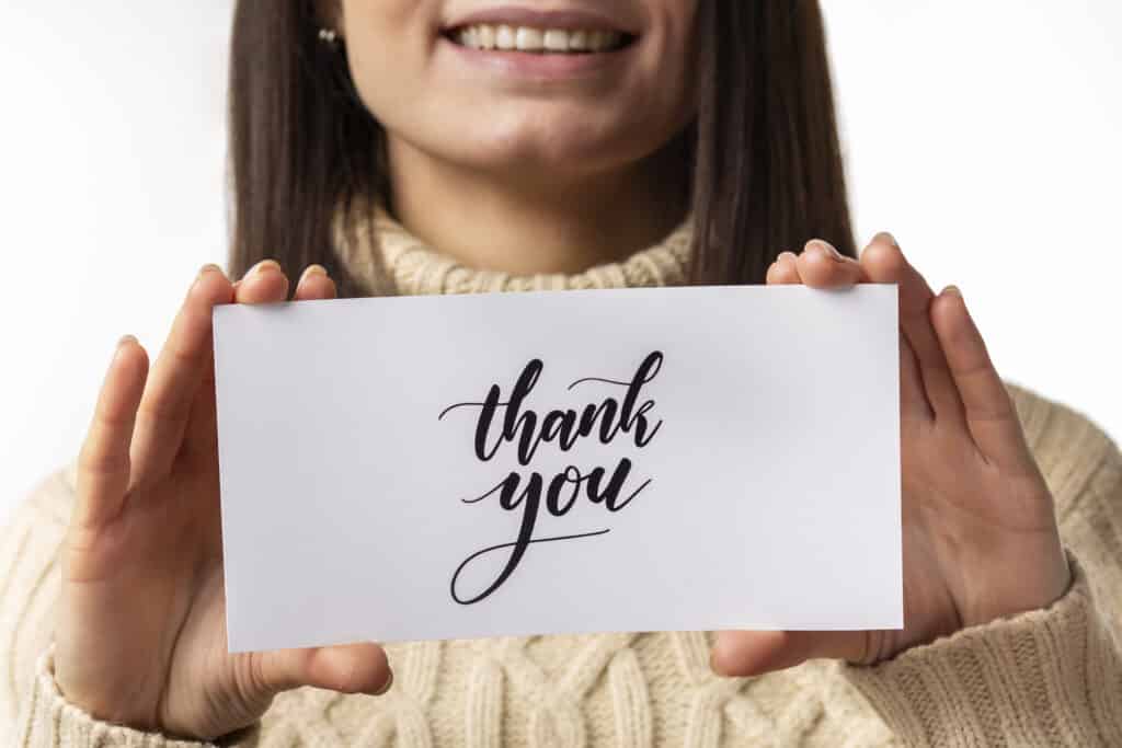 Image with a woman holding a thank you card