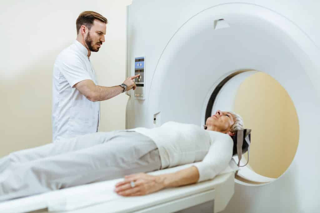 Image of an MRI technologist operating a CT scan machine at a clinic.