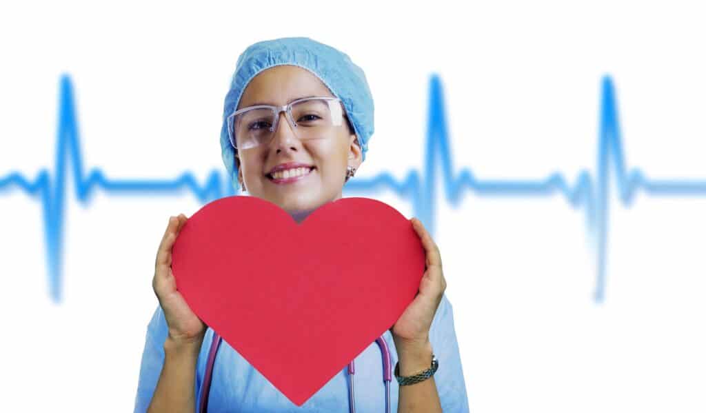 Image of a smiling health professional holding a heart